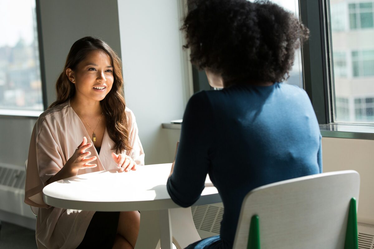 A career coach and a job seeker in a mock interview at a small table